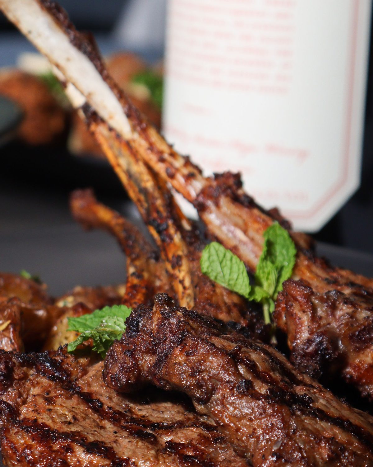 Rack of marinated lamb chops standing on a black plate
