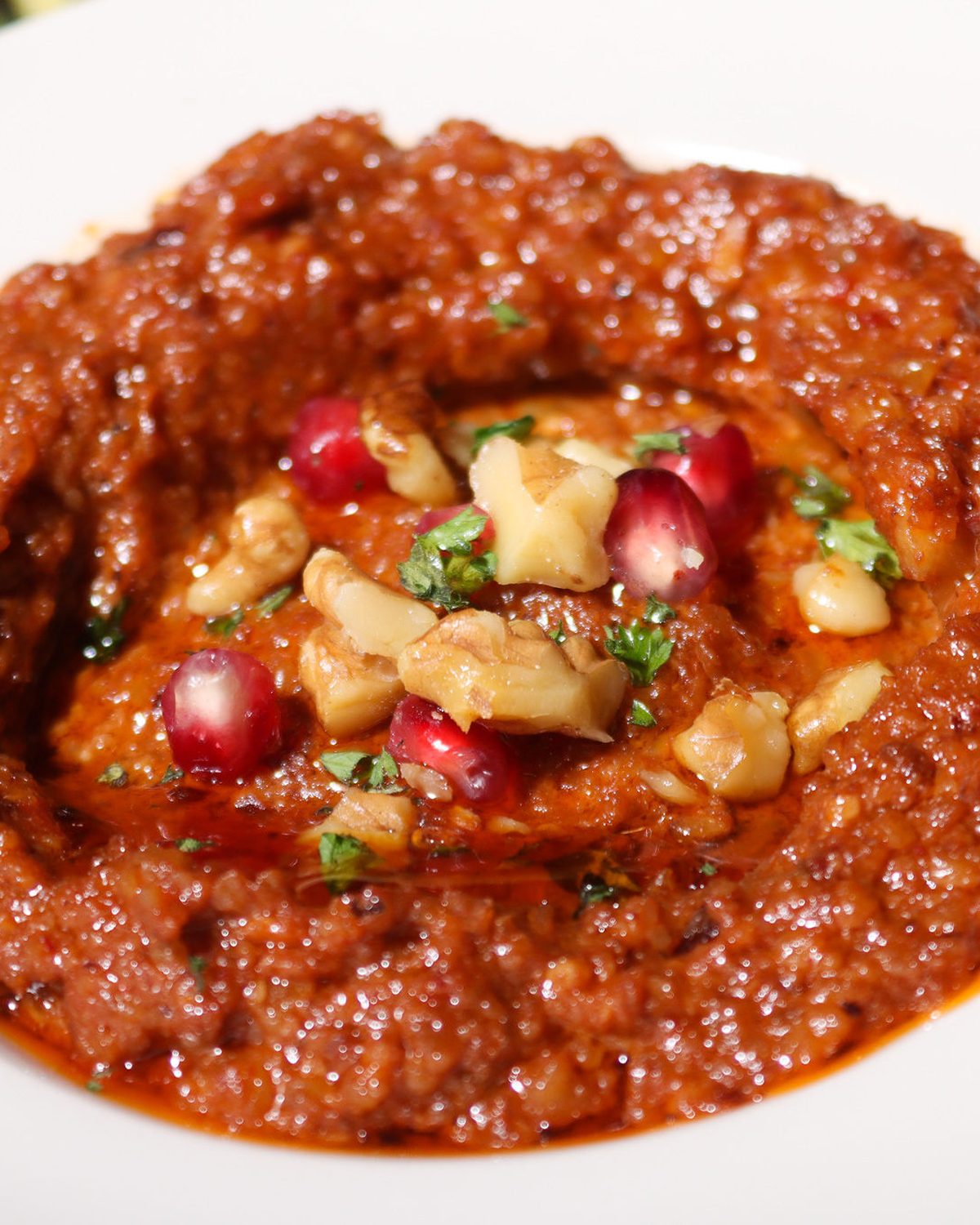 Muhammara topped with walnuts and pomegranate seeds