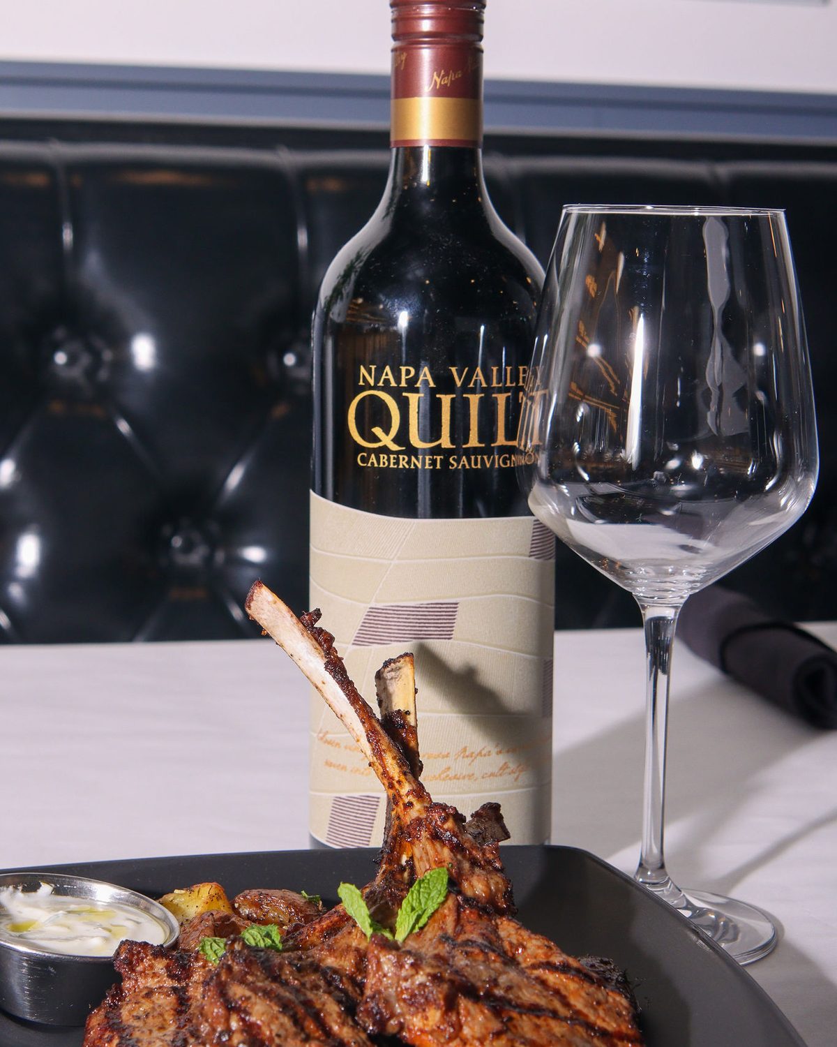 Lamb chops and Cabernet on a set table