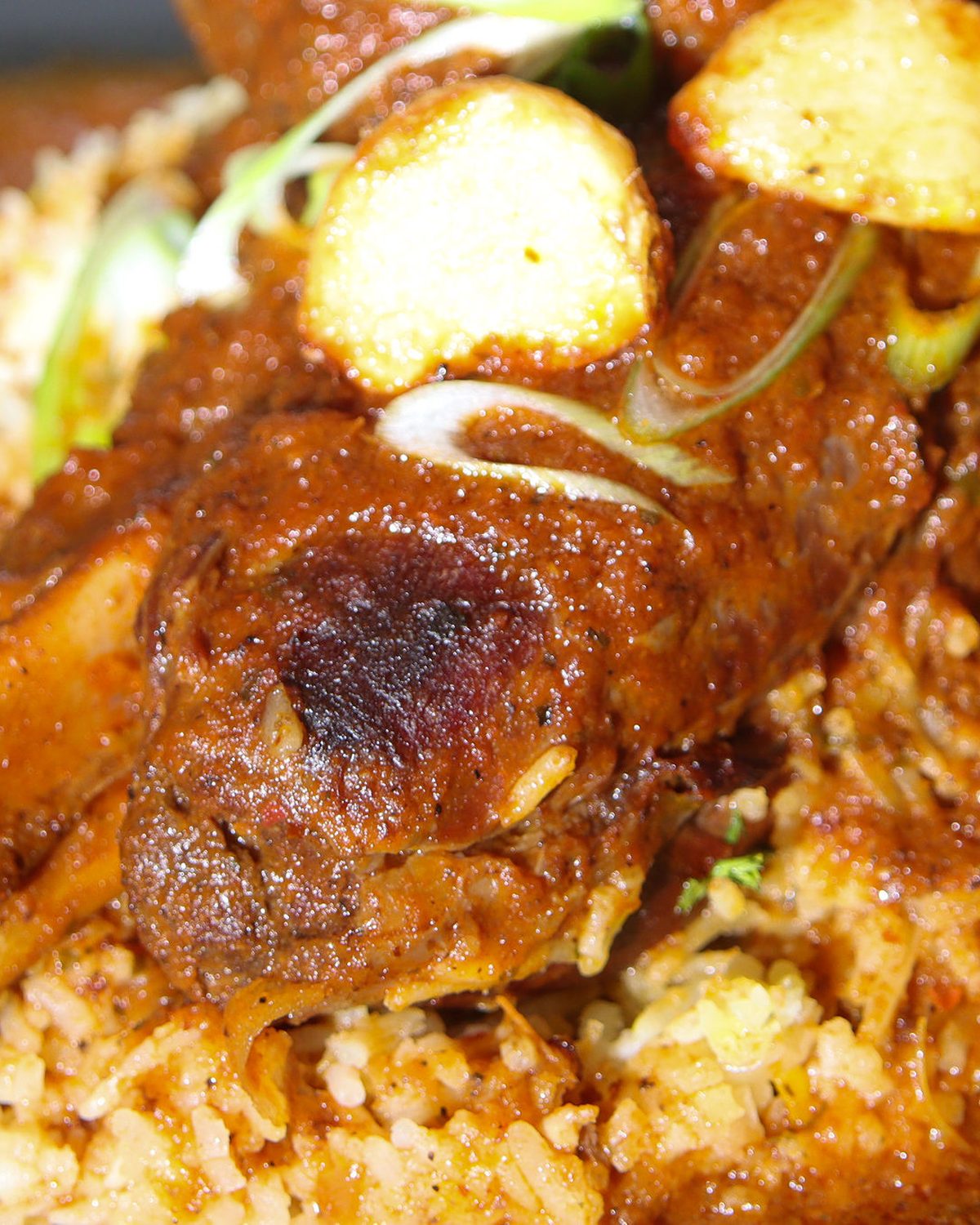 Lamb shank falling from the bone over rice