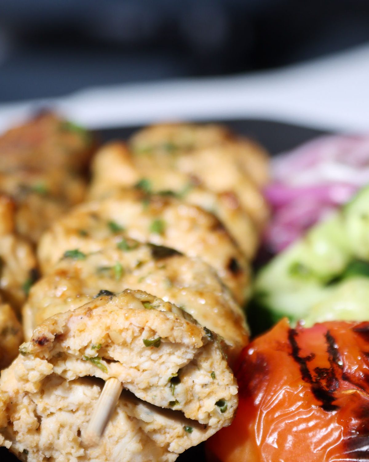 Chicken kabob with grilled tomato and cucumber salad